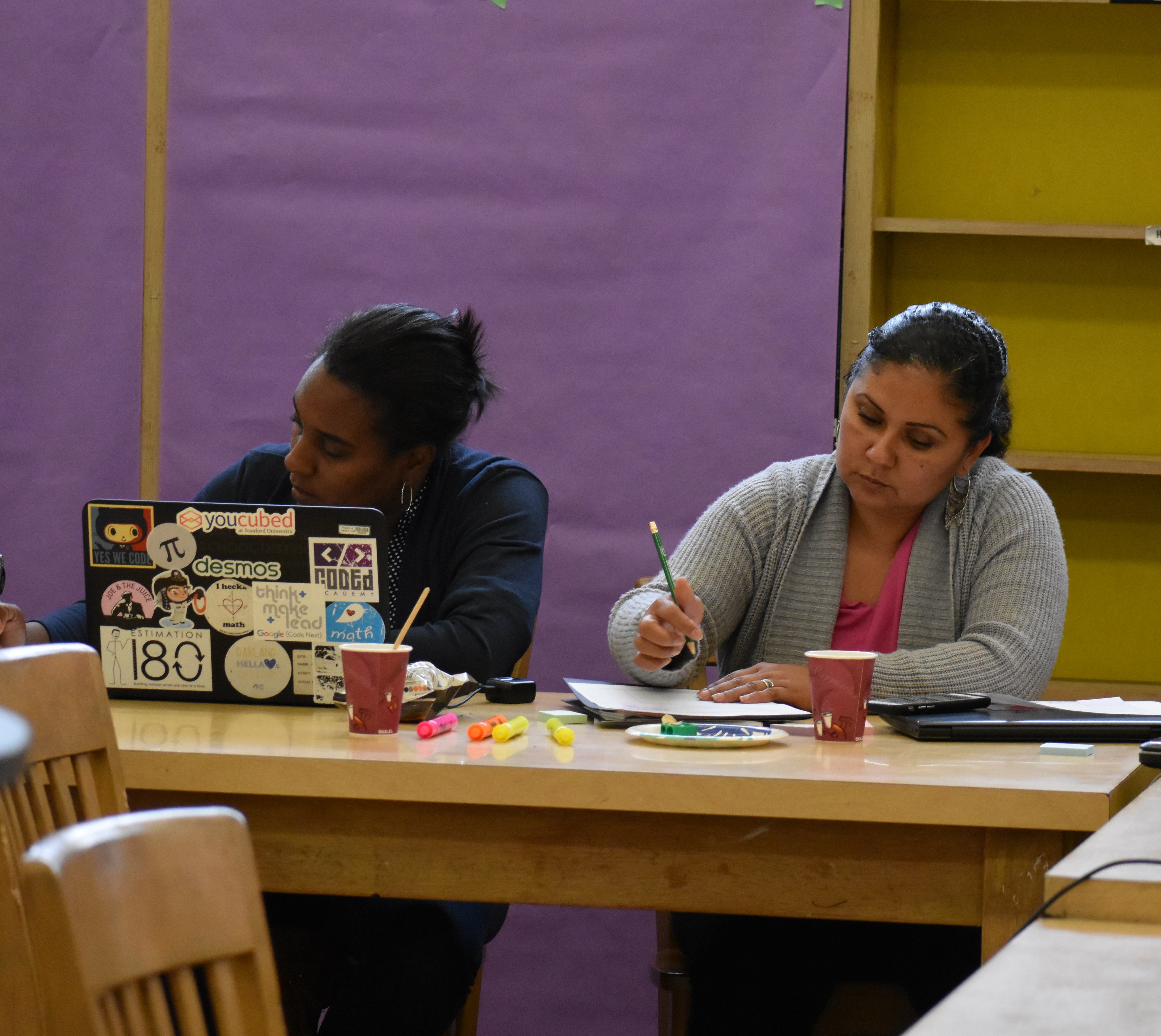 Two teachers write reflections on a lesson study cycle as part of a end-of-cycle meeting