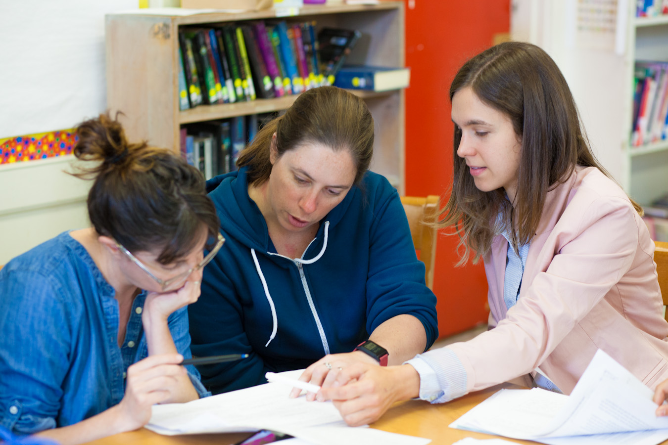 Three teachers discussing materials Three teachers discussing materials
