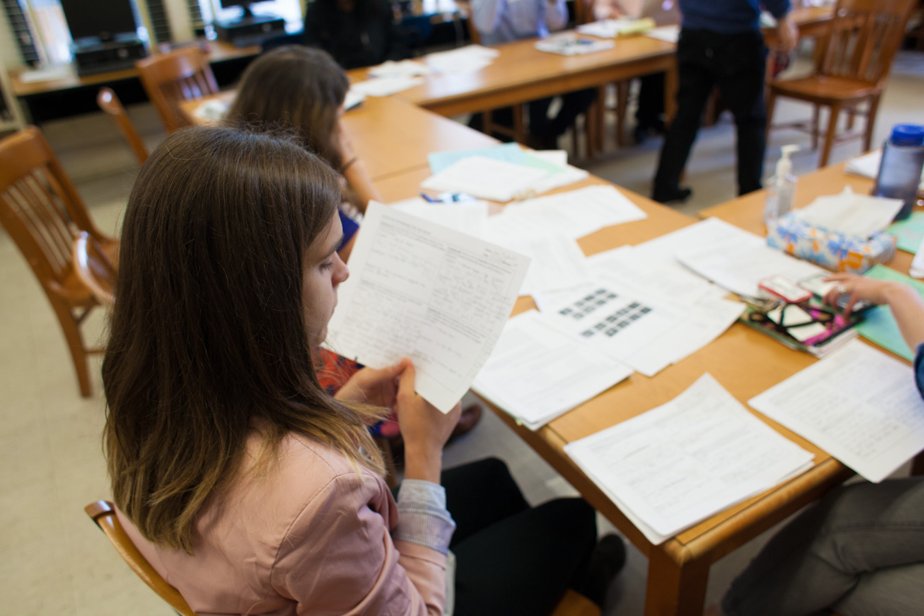 Over shoulder of teacher looking at paper