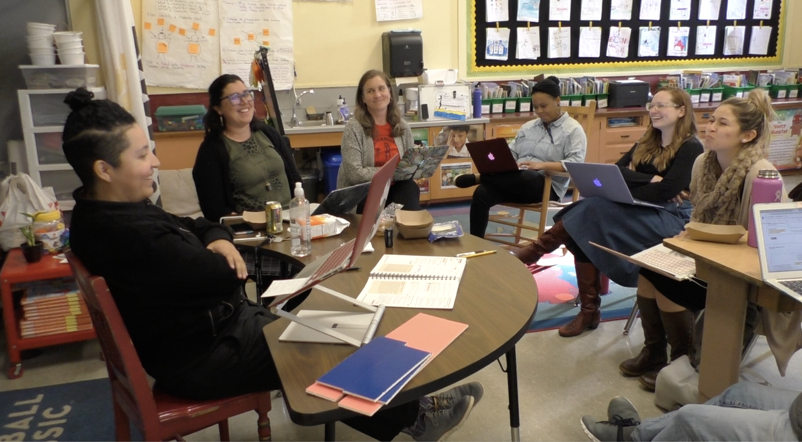 Screen Shot 2021-03-31 at 8.47.05 PM An elementary-age male student points while his female teacher stands beside him and observes